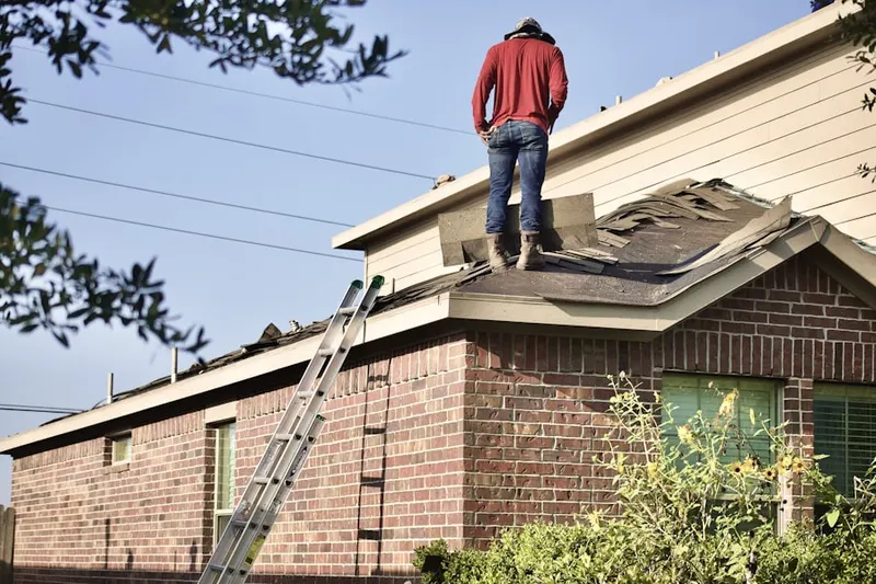 Professional roofer working on a residential roof in Evergreen Heights and Estates